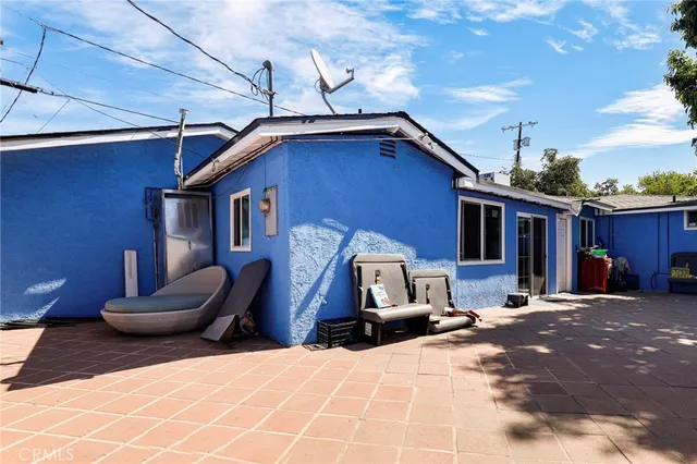 a view of a house with a barbeque and wooden stairs