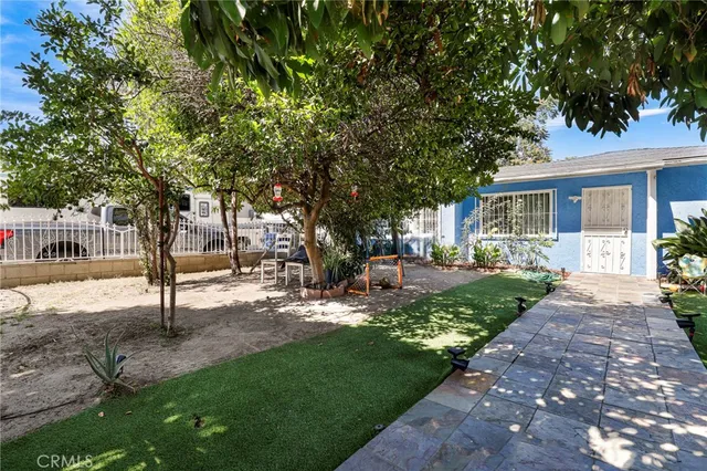 a view of a yard with plants and trees