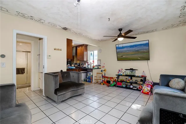 a living room with furniture a flat screen tv and kitchen view