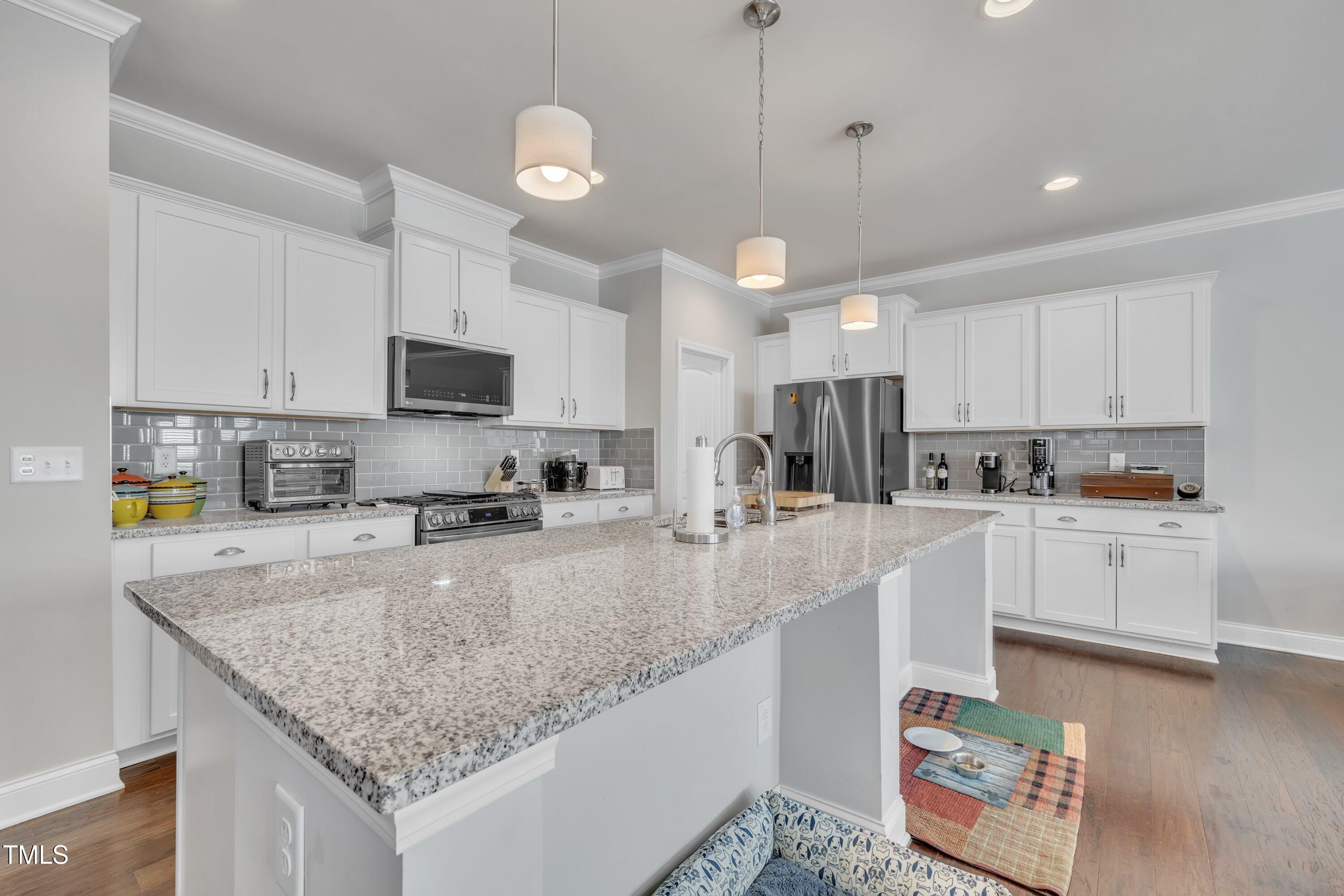 640 Newlyn Drive Raleigh, NC 27606 - Photo 10 of 44 a kitchen with stainless steel appliances granite countertop a sink a stove and a center island