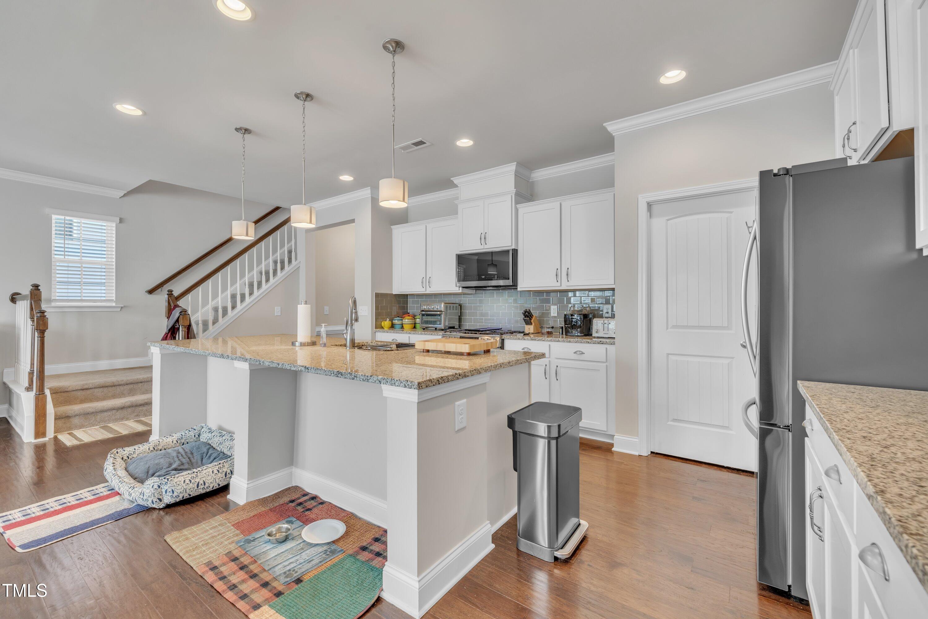 640 Newlyn Drive Raleigh, NC 27606 - Photo 12 of 44 a kitchen with kitchen island white cabinets and stainless steel appliances