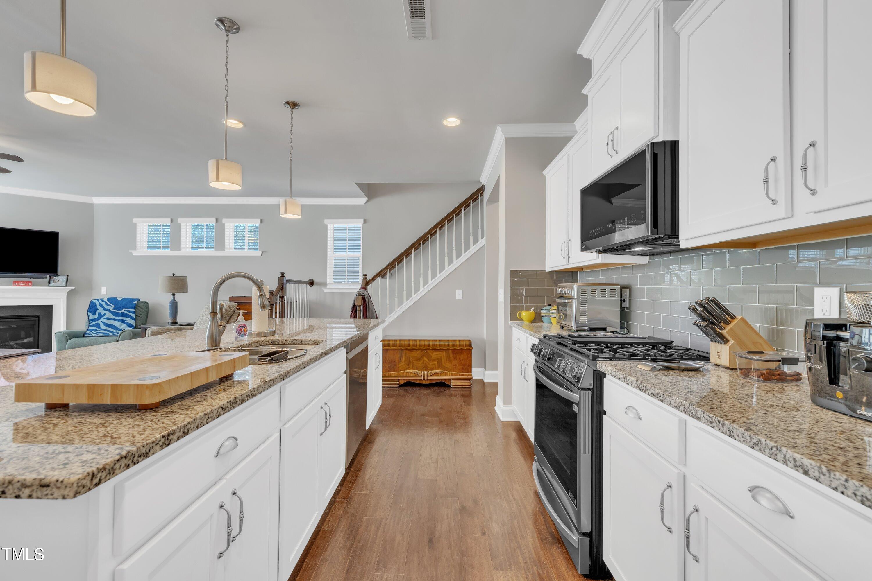 640 Newlyn Drive Raleigh, NC 27606 - Photo 13 of 44 a large kitchen with granite countertop a sink a stove top oven and cabinetry