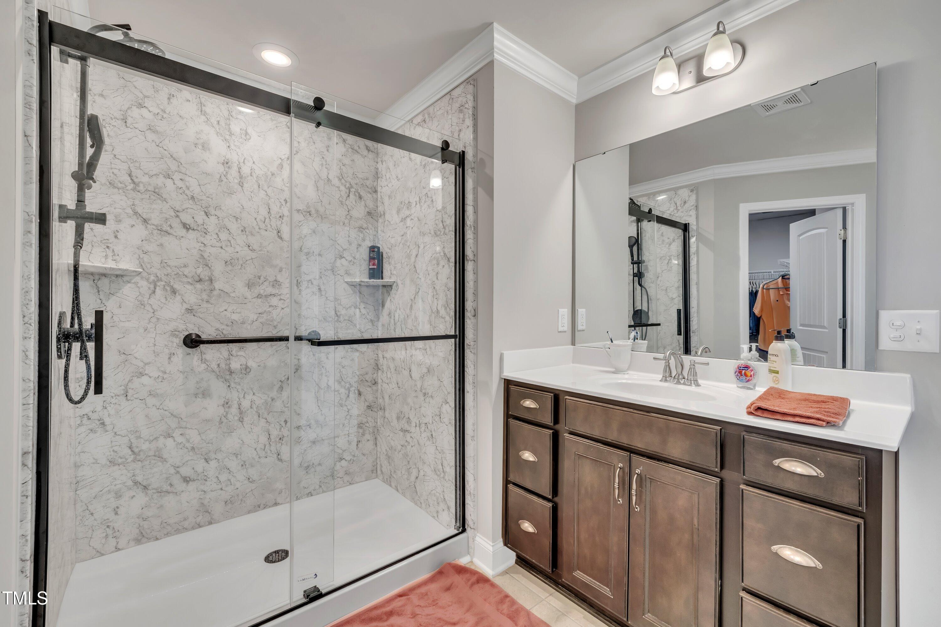 640 Newlyn Drive Raleigh, NC 27606 - Photo 29 of 44 a bathroom with a shower sink and mirror