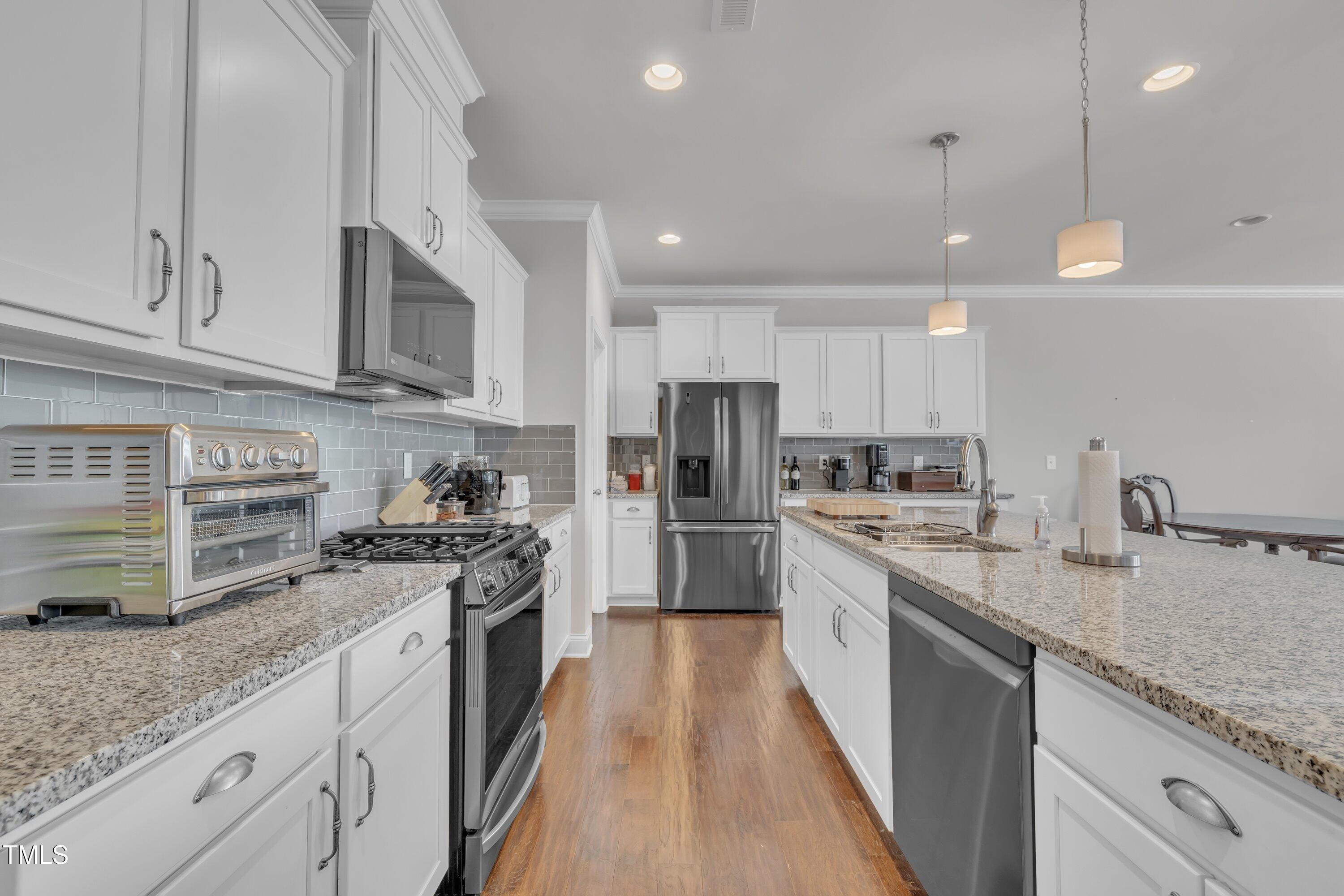 640 Newlyn Drive Raleigh, NC 27606 - Photo 9 of 44 a large kitchen with stainless steel appliances granite countertop a stove a sink and a refrigerator