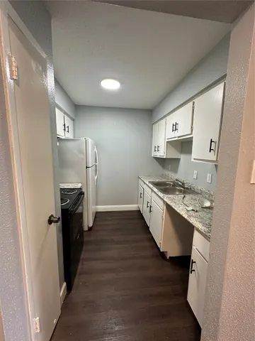 a large kitchen with a stove a sink and a refrigerator