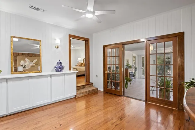 a view of a big room with wooden floor and windows