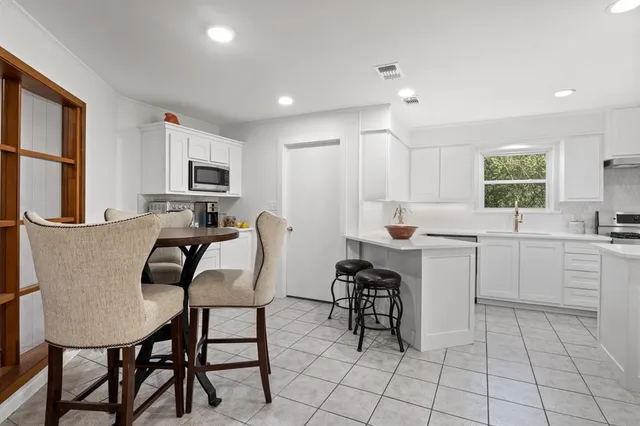 a kitchen with white cabinets and appliances