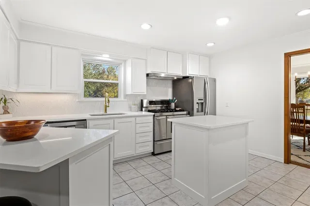 a kitchen with cabinets appliances a sink and a counter top space