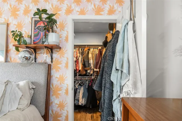 a view of walk in closet with clothes and shoes