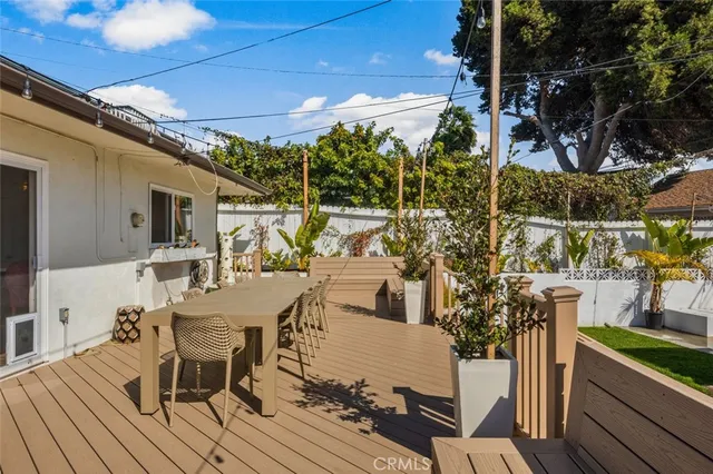 a view of a patio with table and chairs with wooden floor and fence