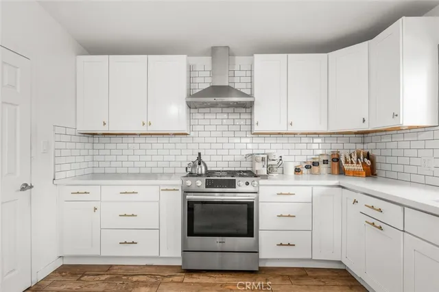 a kitchen with white cabinets and appliances
