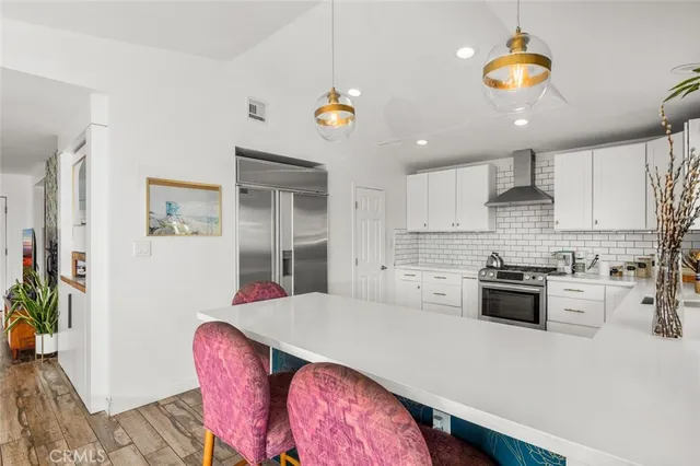 a kitchen with a table chairs stove and white cabinets