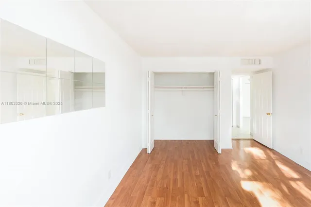 a view of a room with wooden floor and a ceiling fan