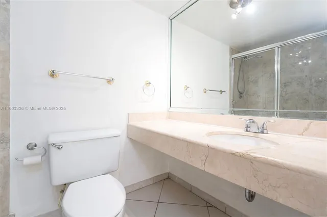 a bathroom with a granite countertop toilet sink and mirror