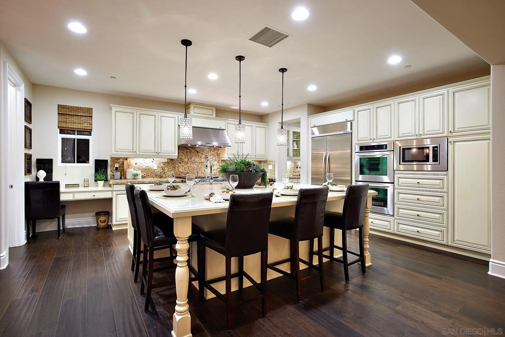 17778 Ralphs Ranch Road San Diego, CA 92127 - Photo 15 of 48 a kitchen with stainless steel appliances kitchen island granite countertop a table chairs and a refrigerator