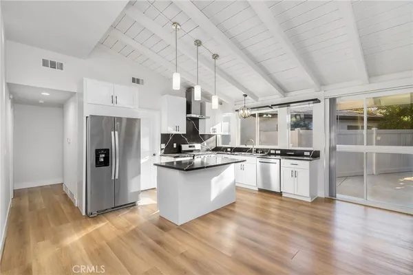 a kitchen with stainless steel appliances granite countertop a refrigerator and a stove top oven