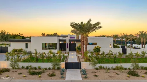 a front view of a house with a yard and potted plants