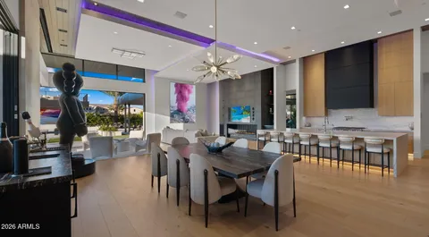 a view of kitchen with stainless steel appliances granite countertop living room and couches with wooden floor
