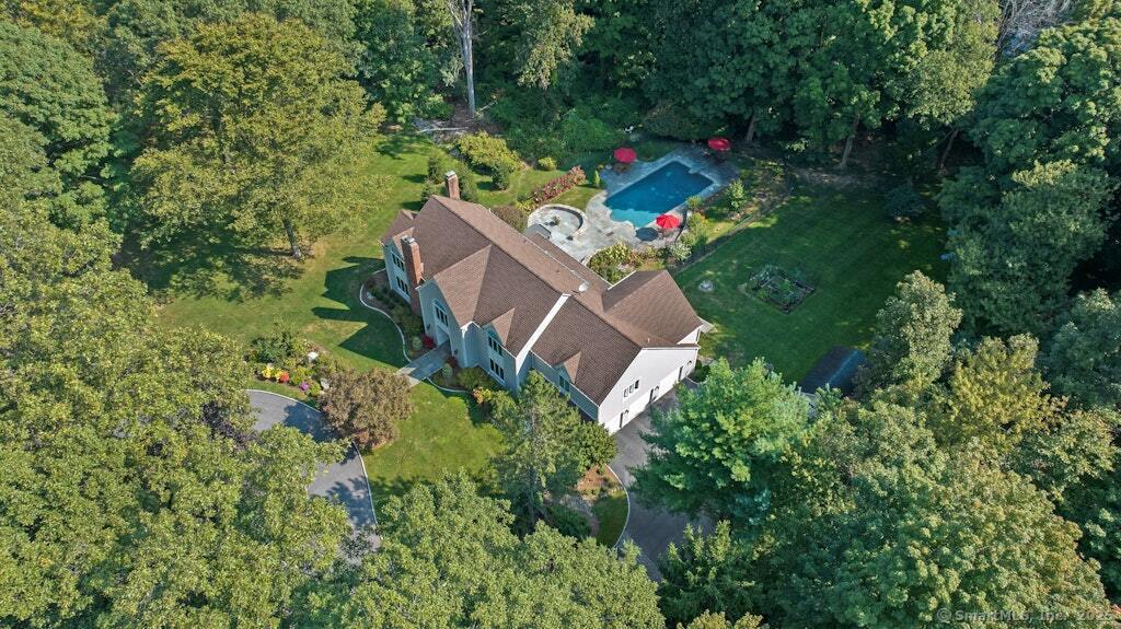 an aerial view of a house with a yard and trees