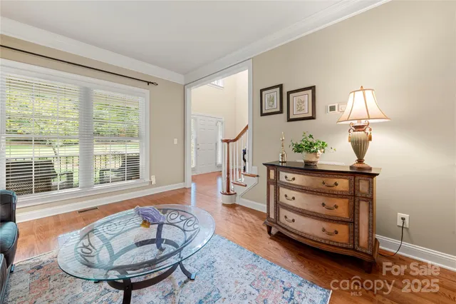 a large kitchen with granite countertop a stove a sink dishwasher and white cabinets with wooden floor