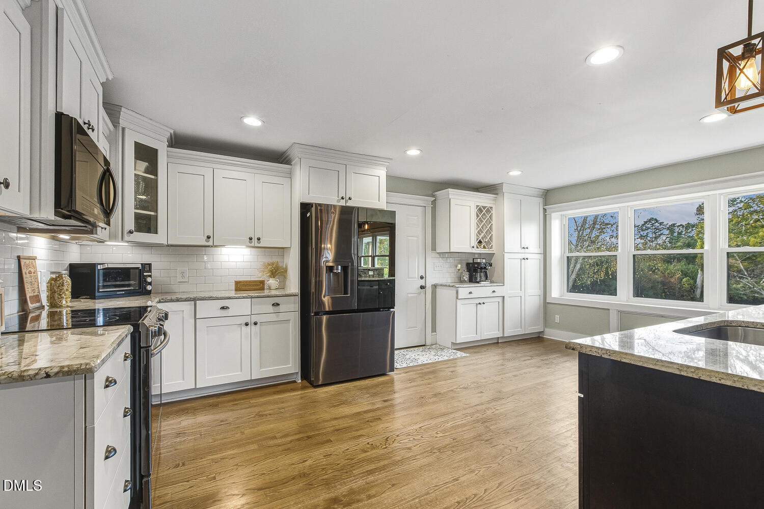 273 Wells Lane Angier, NC 27501 - Photo 13 of 52 a large kitchen with stainless steel appliances granite countertop a refrigerator oven a sink dishwasher a dining table and chairs with wooden floor