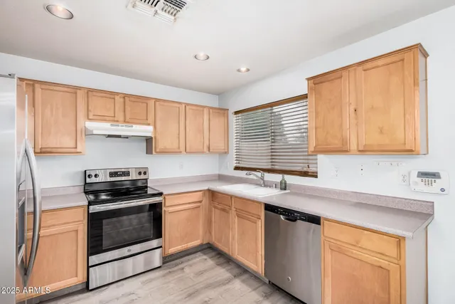 a kitchen with a sink stove top oven and cabinets
