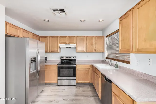 a kitchen with stainless steel appliances granite countertop a sink stove and refrigerator