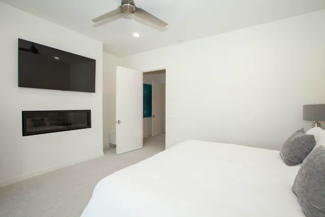 a bedroom with a large bed and a flat tv screen