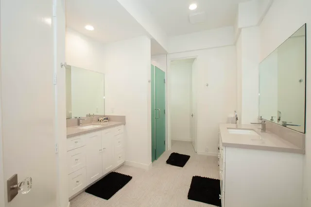 a bathroom with a double vanity sink toilet and mirror