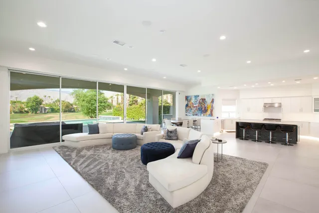 a living room with fireplace furniture and a large window