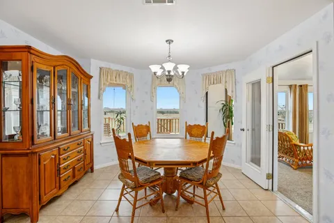a dining room with furniture a chandelier and window