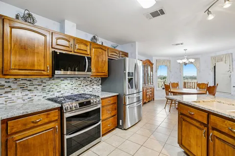 a kitchen with stainless steel appliances granite countertop a stove microwave and refrigerator