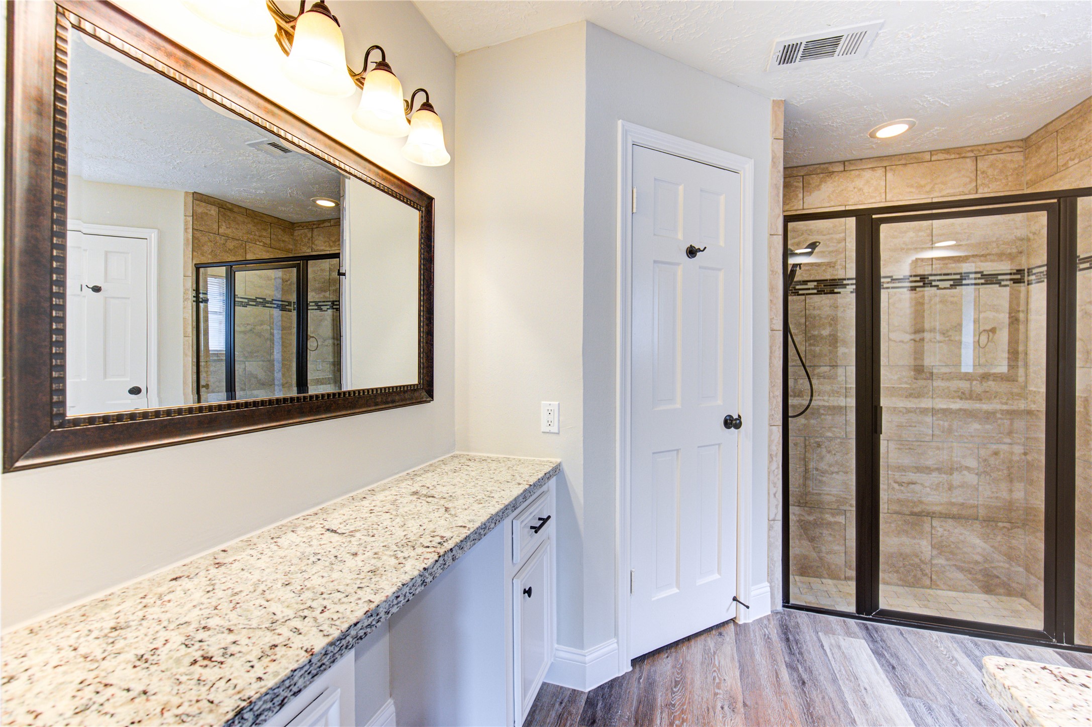 9115 Taidswood Drive Spring, TX 77379 - Photo 24 of 45 The primary bath has double sinks, and a separate vanity area. The shower has decorative mosaic inserts, and a glass shower door.