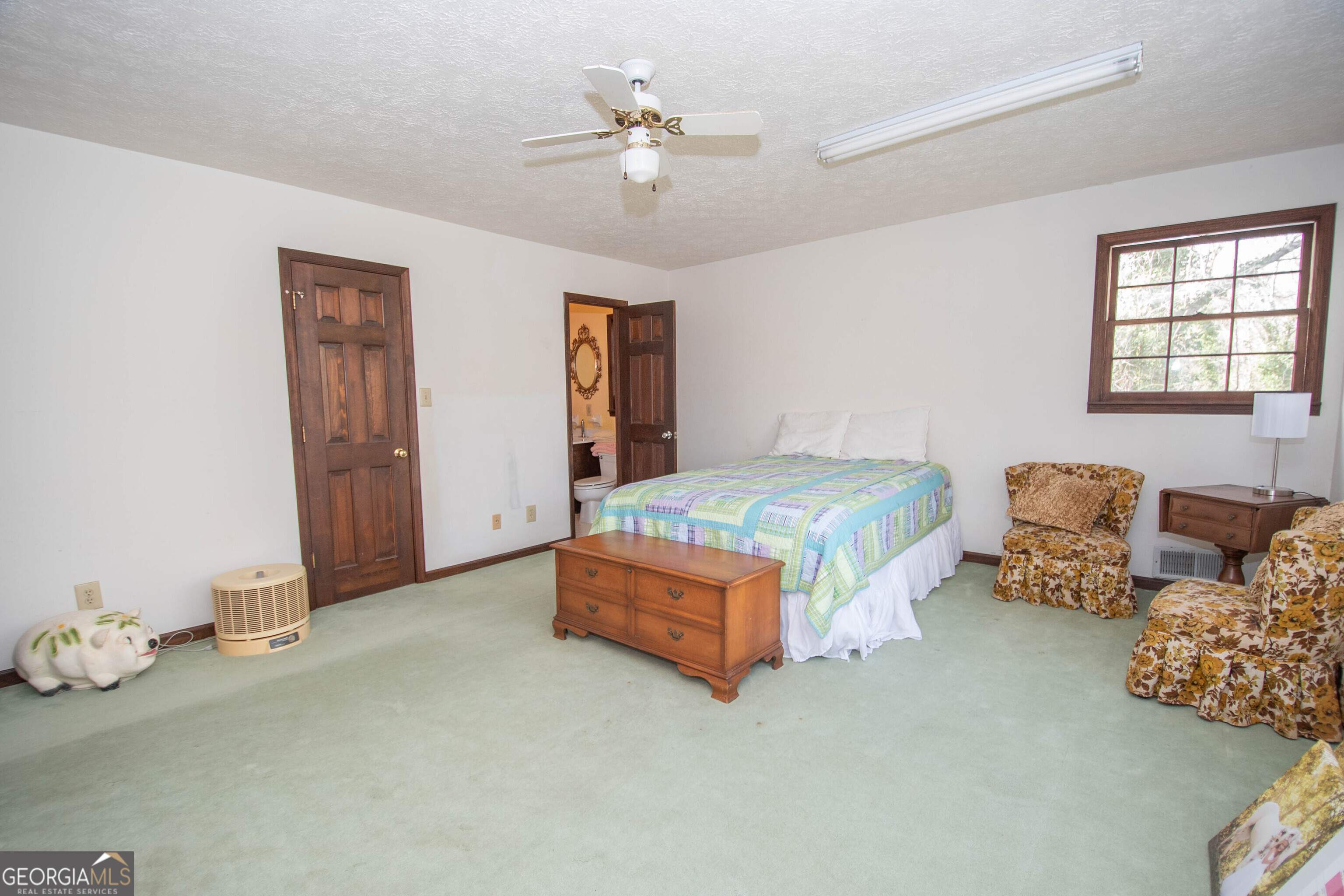 151 Evans Road Milner, GA 30257 - Photo 23 of 60 a spacious bedroom with a bed and a chandelier