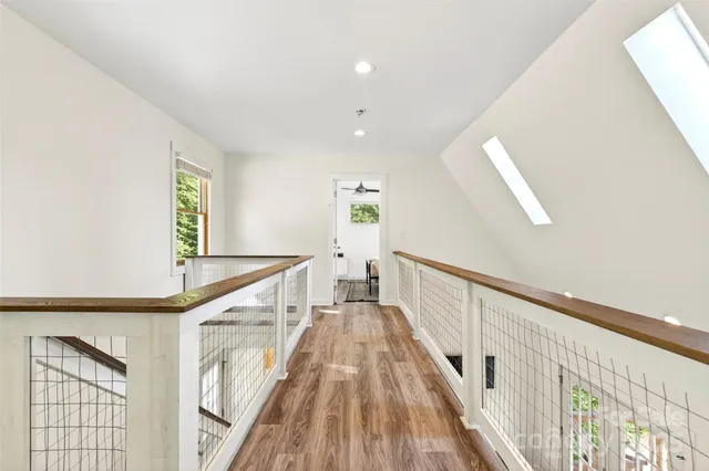 a view of a hallway with wooden floor and staircase
