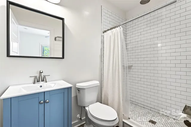 a bathroom with a toilet a sink and mirror