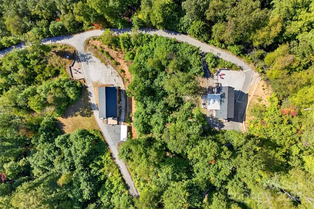 an aerial view of residential house with outdoor space and trees all around