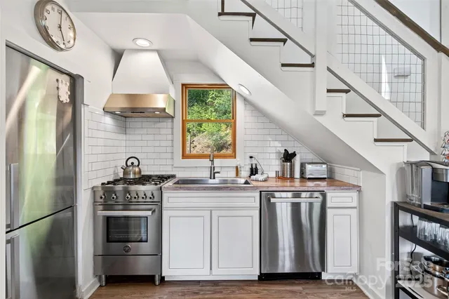 a kitchen with kitchen island granite countertop a stove a sink and a refrigerator