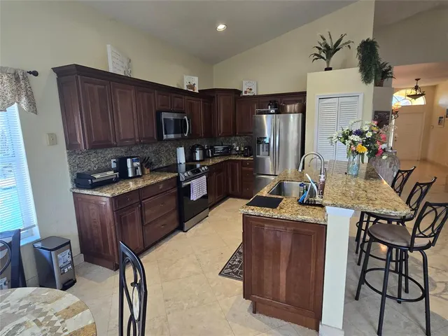 a kitchen with kitchen island granite countertop wooden cabinets and a refrigerator
