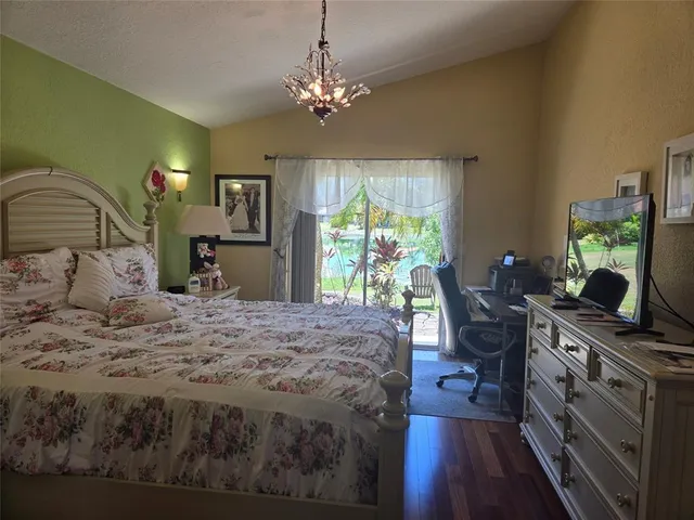 a bedroom with a bed window and a flat screen tv