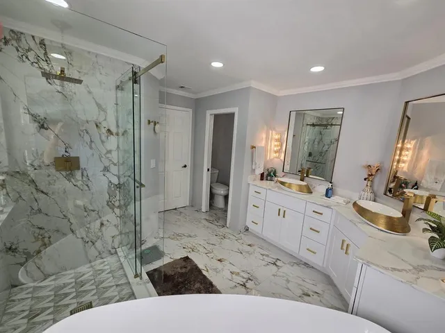 a spacious bathroom with a double vanity sink toilet mirror and bathtub