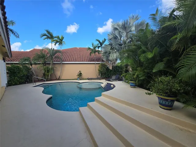 a view of swimming pool with outdoor seating and plants