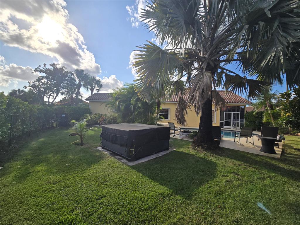 22112 Altona Drive Boca Raton, FL 33428 - Photo 28 of 40 a view of a backyard with table and chairs potted plants and palm trees