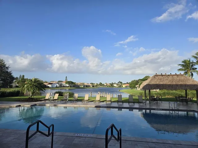 a view of swimming pool with outdoor seating and lake view