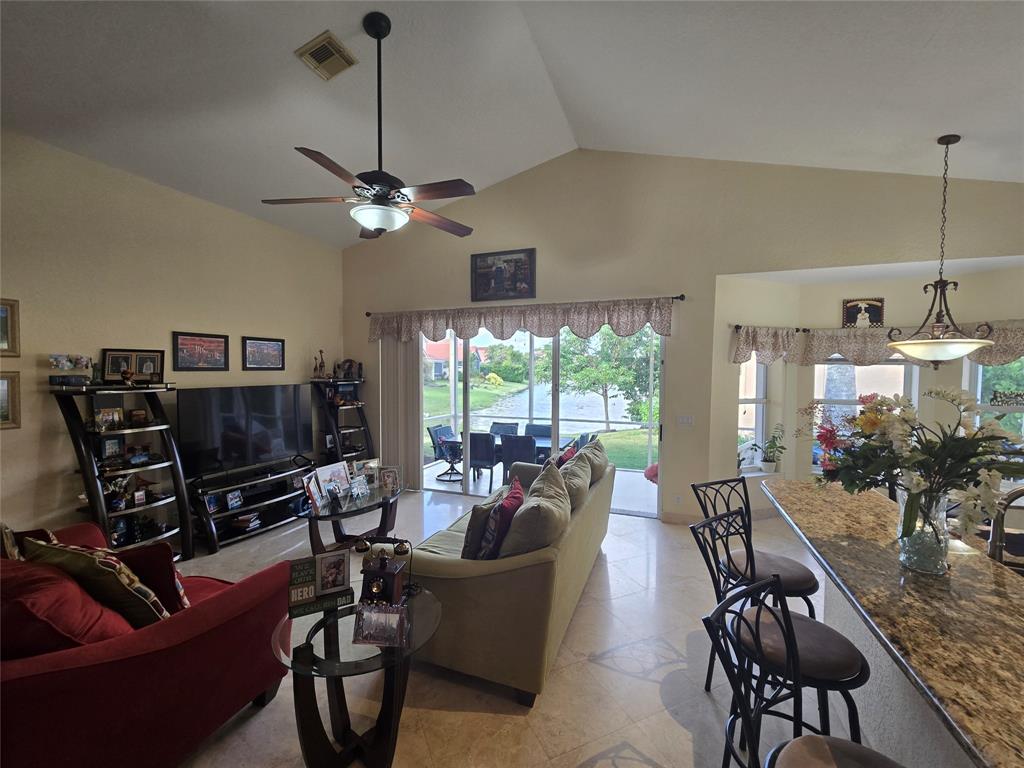 22112 Altona Drive Boca Raton, FL 33428 - Photo 10 of 40 a living room with furniture a ceiling fan a flat screen tv and a large window