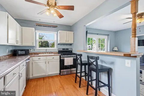 a kitchen with stainless steel appliances granite countertop wooden floor window and cabinets
