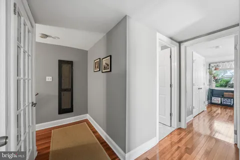 a view of a hallway with bathroom and wooden floor