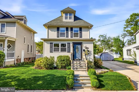 a front view of a house with a yard and trees