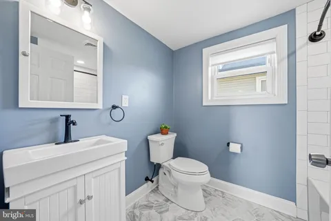 a bathroom with a toilet sink and mirror