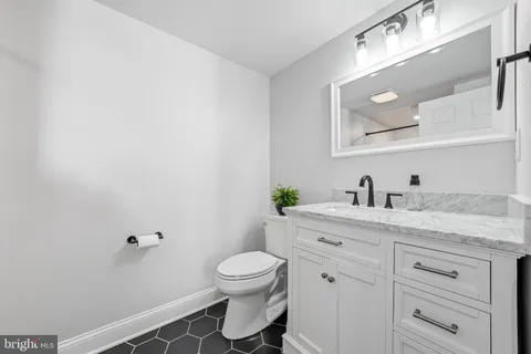 a spacious bathroom with a granite countertop sink mirror and toilet